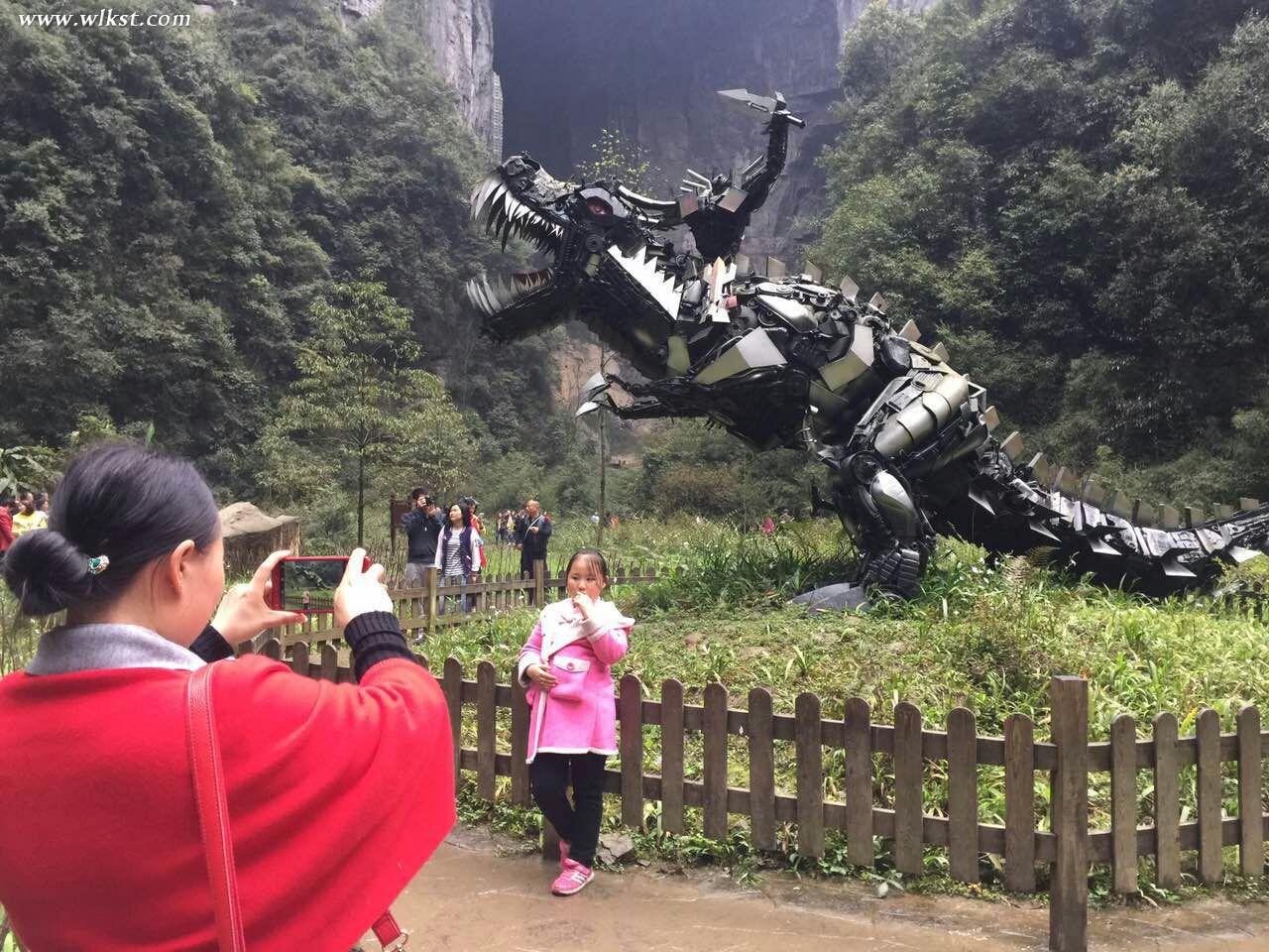 游客與機械龍模型合影